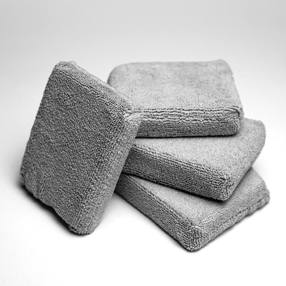 Čtyři šedé mikrovláknové aplikátory Feynlab Lined Applicator Pad poskládané na sobě