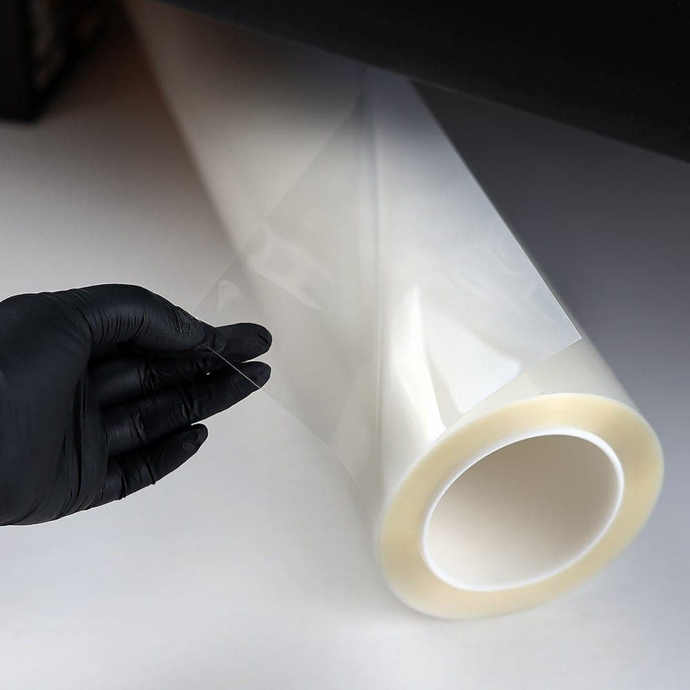 Detailní pohled na extrémní flexibilitu a absolutní optickou čistotu lesklé ochranné fólie Feynlab PPF Flex před instalací.